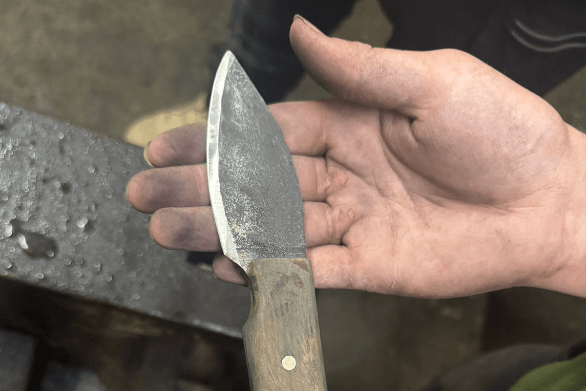 hand holding hand forged knife during knife-making at old pound smithy