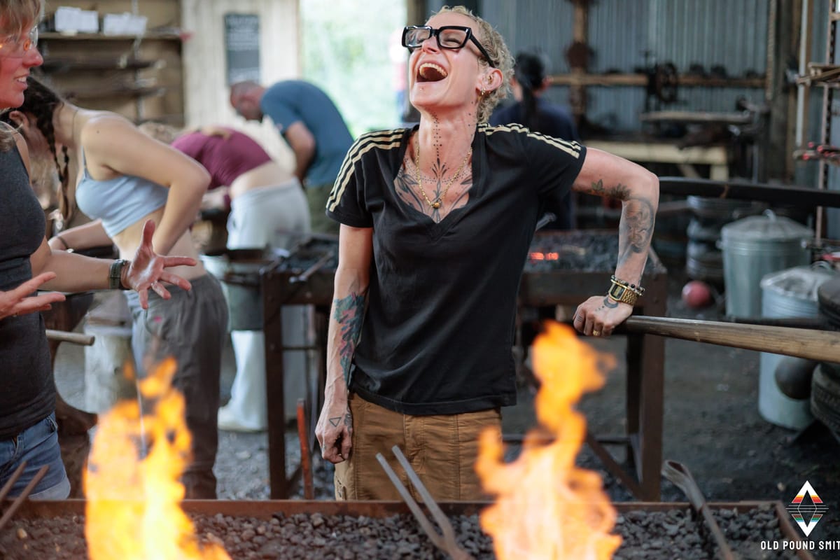 girl laughing while pumping bellows at Old Pound Smithy North Devon