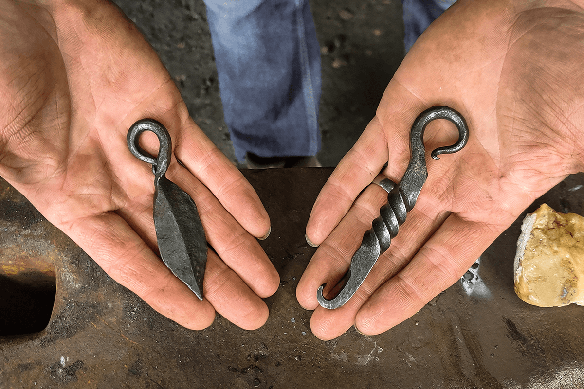 Hands holding forged items at Old Pound Smithy
